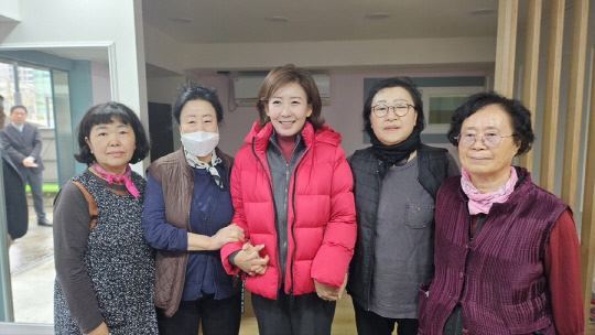국민의힘 서울 동작구을 당협위원장인 나경원(가운데) 전 자유한국당 원내대표는 11월27일 자신의 SNS에 지역구 주민들과 만나 팔짱을 끼고 함께 찍은 사진을 게재했다.<나경원 전 국회의원 네이버 블로그 사진>